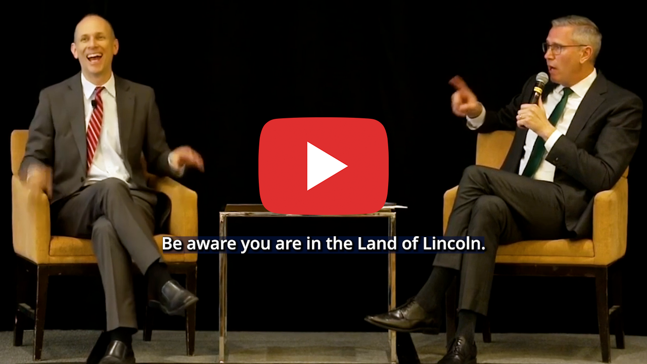 video: Austan Goolsbee and Treasurer Frerichs seated on a stage and talking. Text below the play button says Be aware you are in the Land of Lincoln