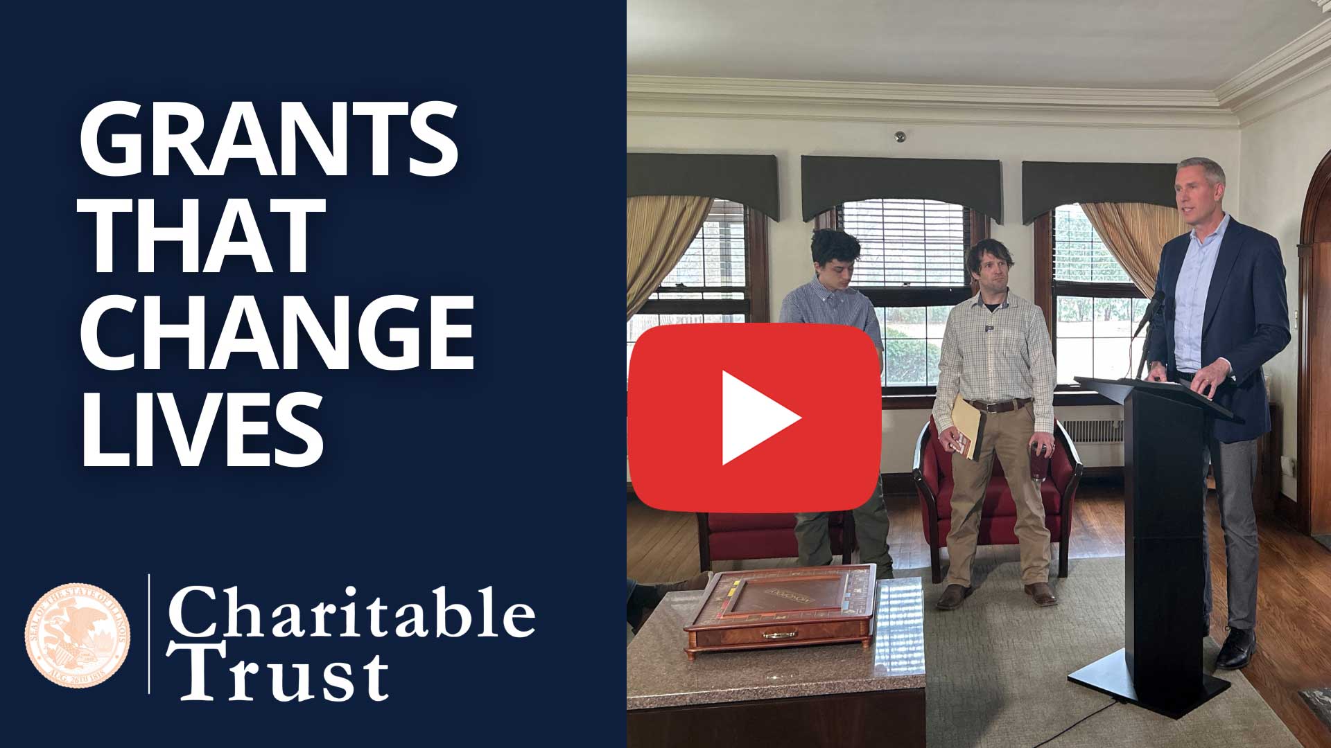 video: Treasurer Frerichs stands at a podium as two young men stand beside him. Text says Grants that Change Lives, Charitable Trust