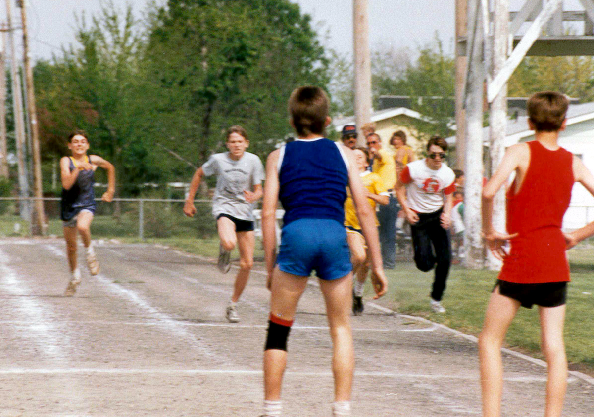 Treasurer Frerichs as a grade school athlete, running a race and wearing a gray shirt as other boys run or watch